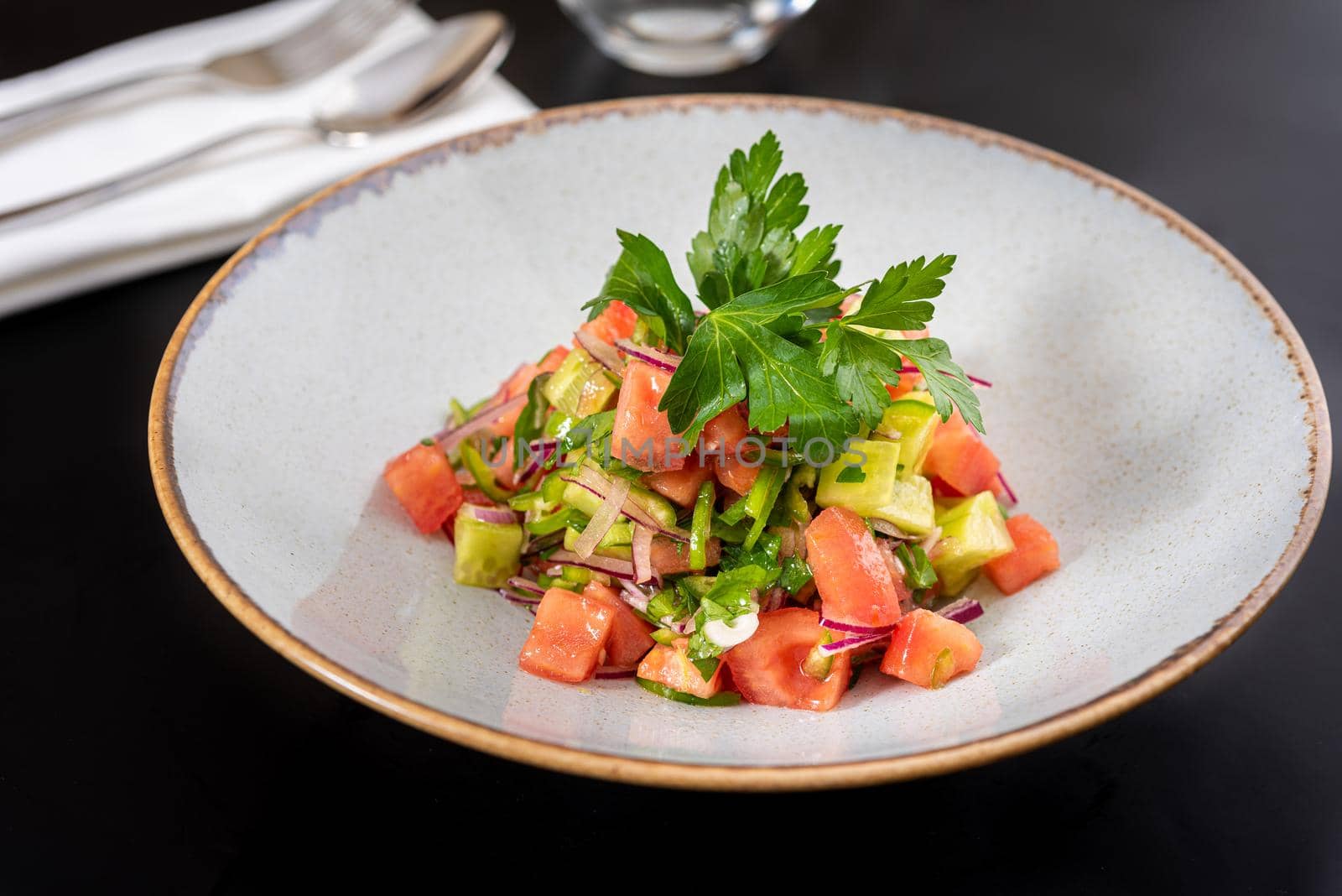 Turkish Coban (choban) salata or Shepherds salad on black table. by Sonat