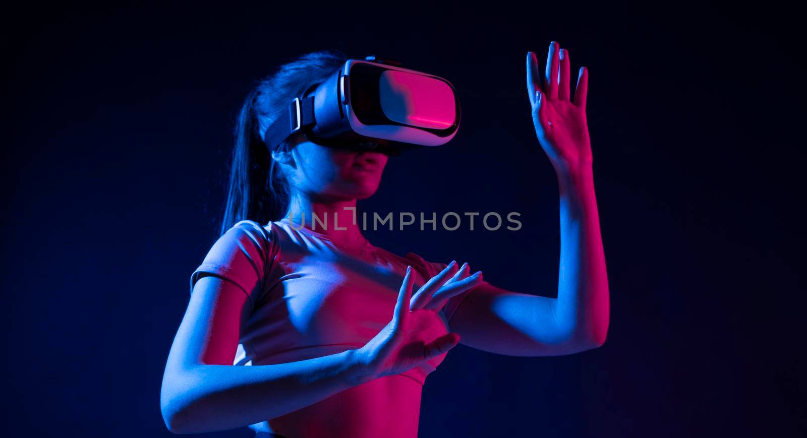 Brunette woman Architect worker wearing VR headset for working design of new architectural project in dark studio. Technology futuristic virtual reality design