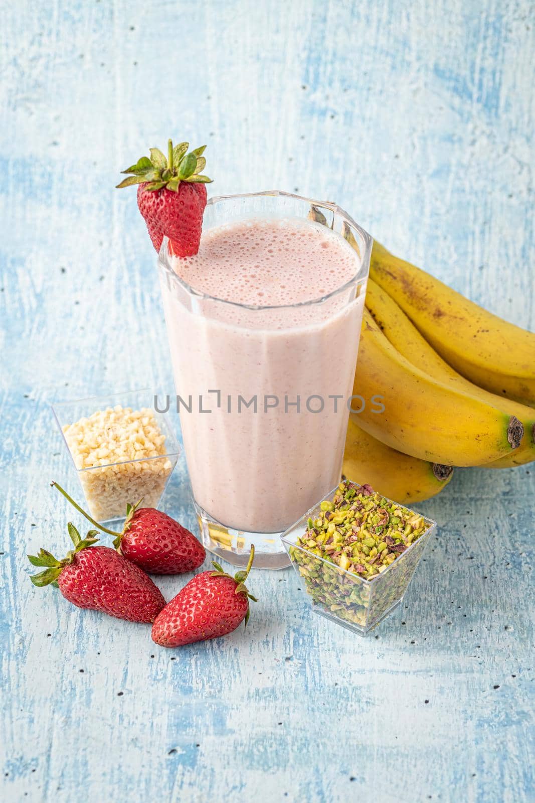 Strawberry and banana cold smoothie on blue background by Sonat