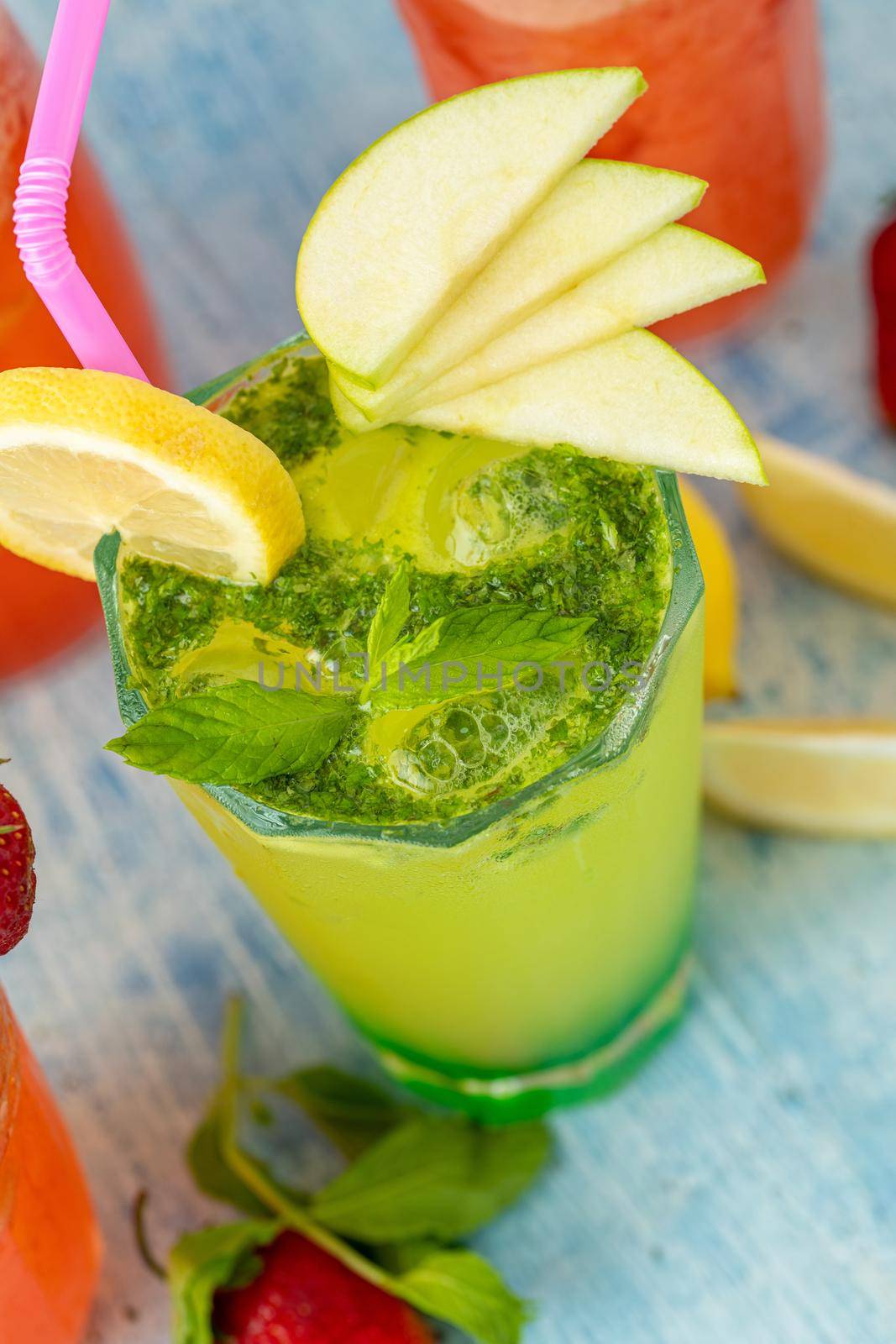 refreshing lemonade with lemon, strawberry and mint on blue background