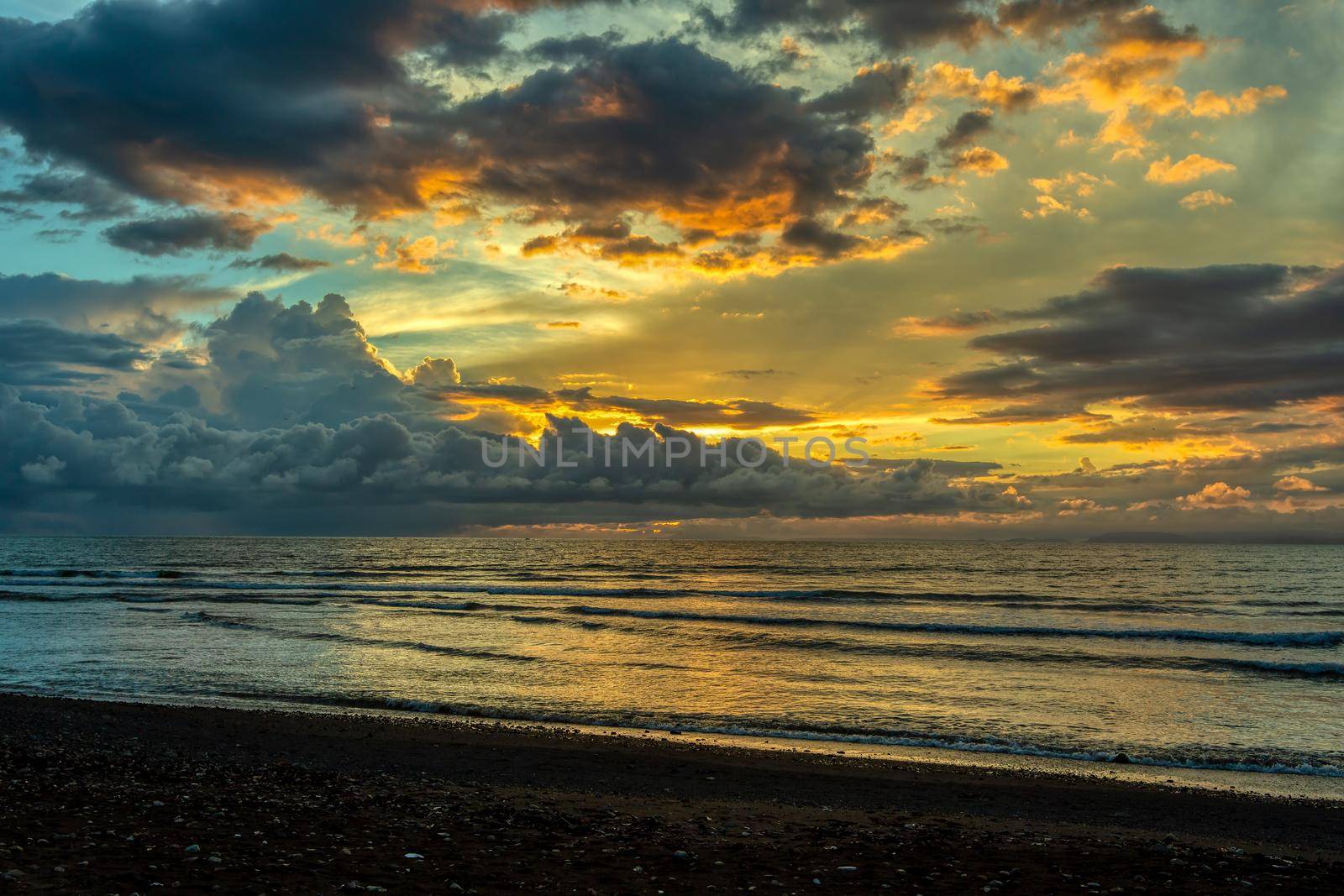 Evening view of the Pacific Coast of Tarcoles in Carara with sunset and glittering waves . Idyllic sunset landscape. Tarcoles, Costa Rica. Pura Vida concept, travel to exotic tropical country.