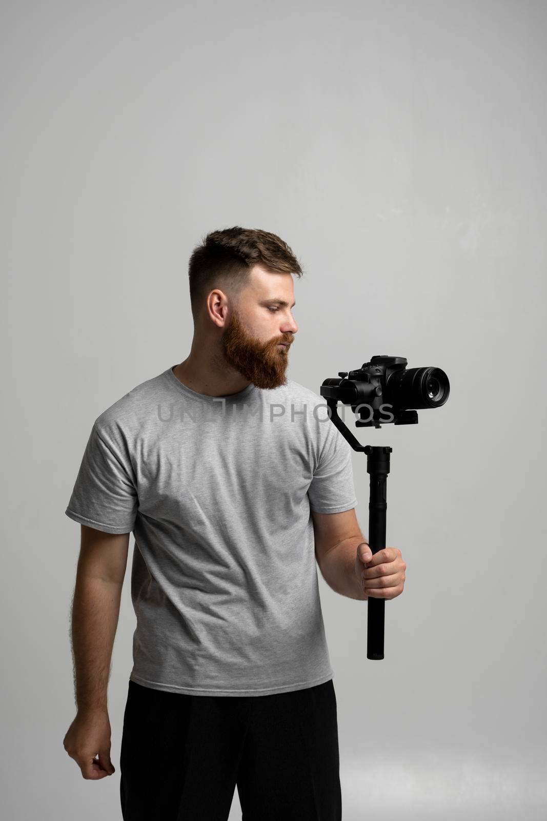 Professional cinematographer with a dslr camera on 3-axis gimbal stabilizer. Filmmaking, videography, hobby and creativity concept