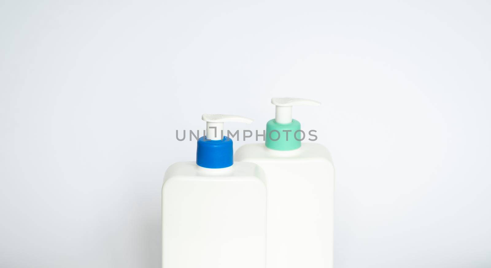 Two white plastic bottles with black dispenser, isolated on white backgroun