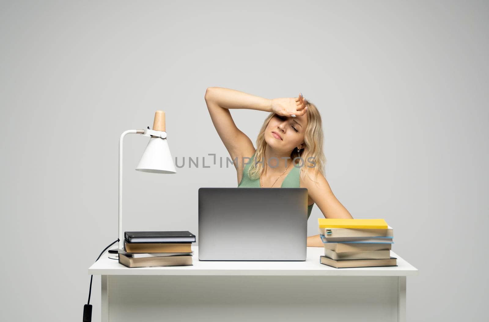 Frustrated, sad, stressed or depressed woman feeling tired while working with a laptop on a white studio background