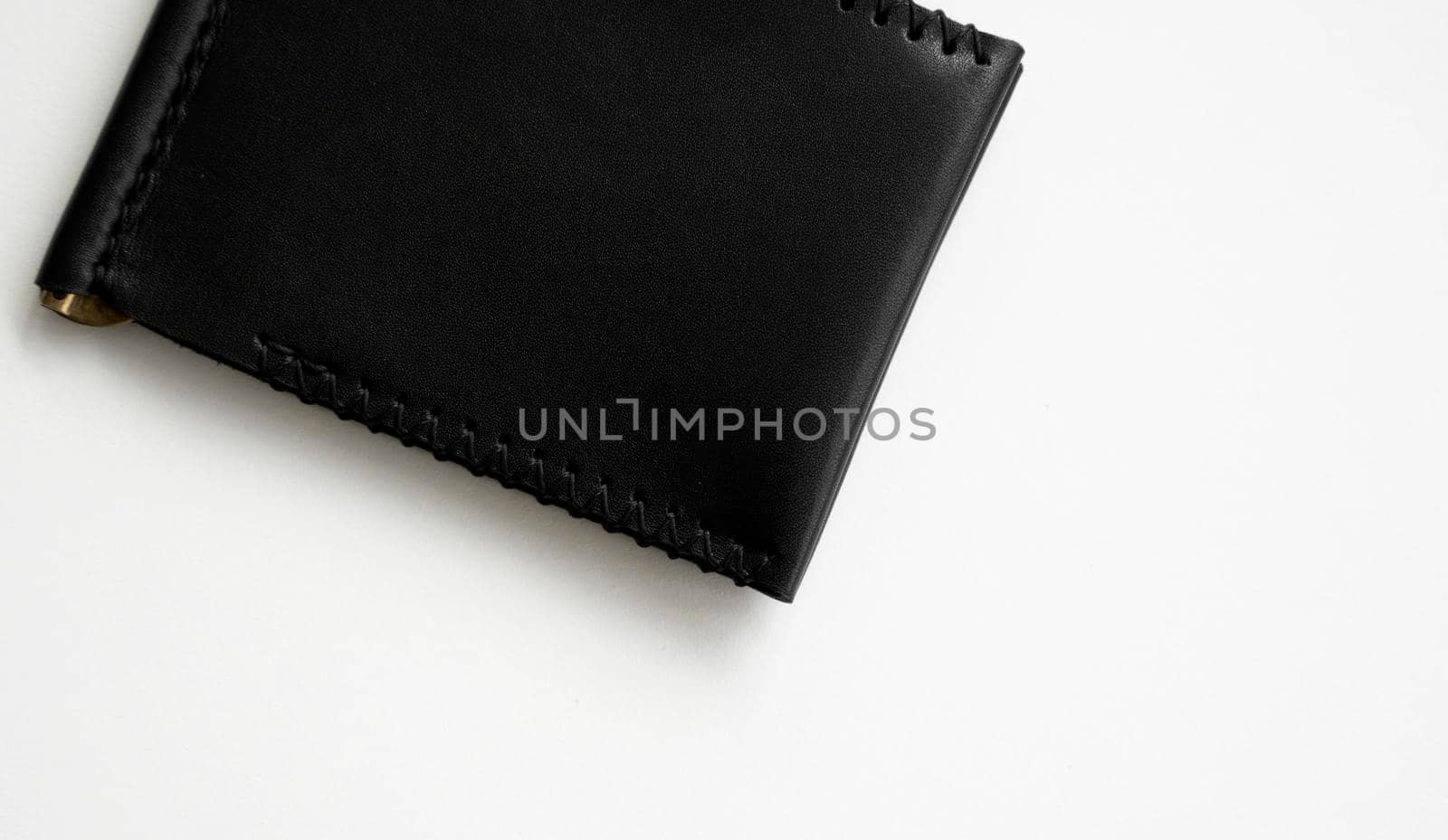 Black money clip handmade from genuine leather on white surface. by vovsht