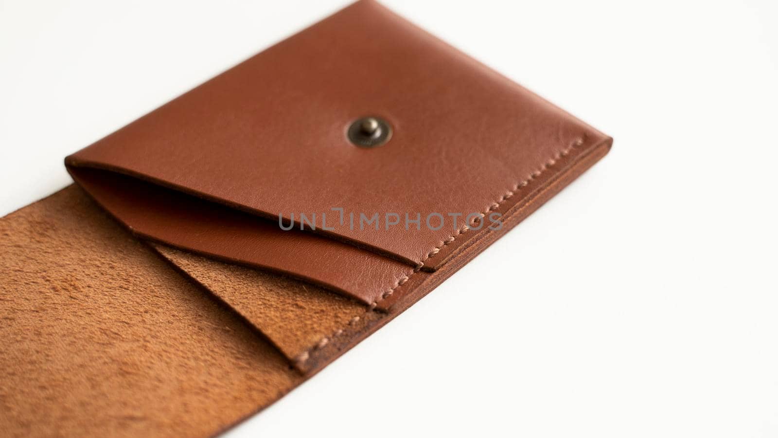 Opened empty orange genuine leather card holder on a white surface