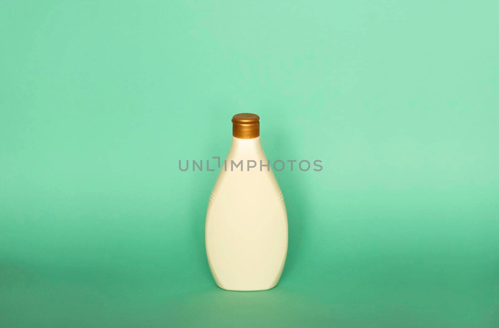 Beige blank plastic bottles isolated on green background