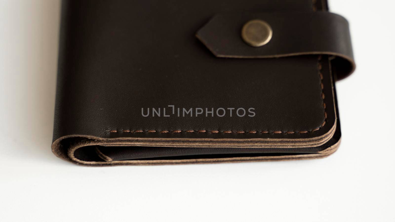 Brown natural genuine leather wallet isolated on white background. Expensive man's purse closeup