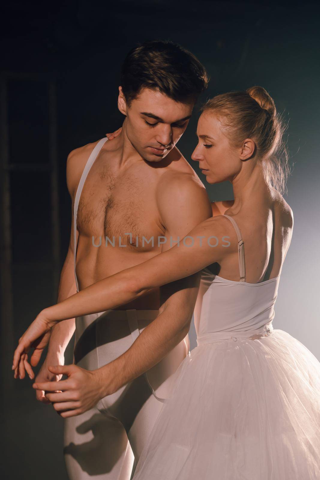 Pair touching each other with hands and passion. Love concept. Professional, sensual ballet dancers performed by sexual couple in white wear