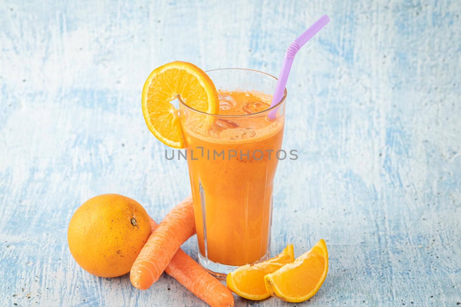 carrot and orange fresh juice on blue table