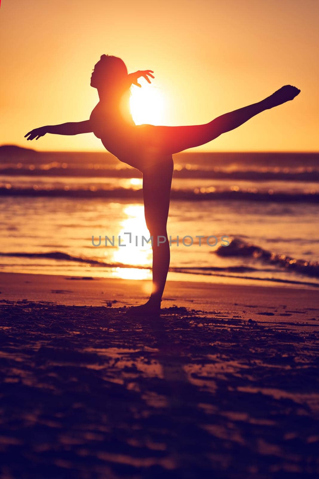 Stay wild at heart. Silhouette of a woman on the beach at sunset