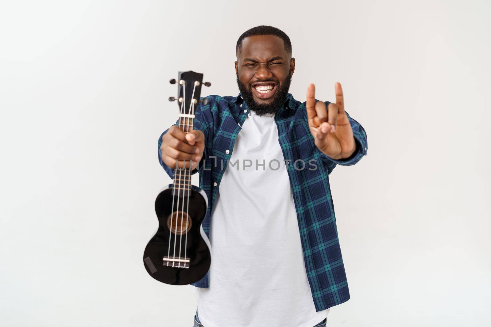 Young handsome african american man plays ukulele isolate over white background. by Benzoix