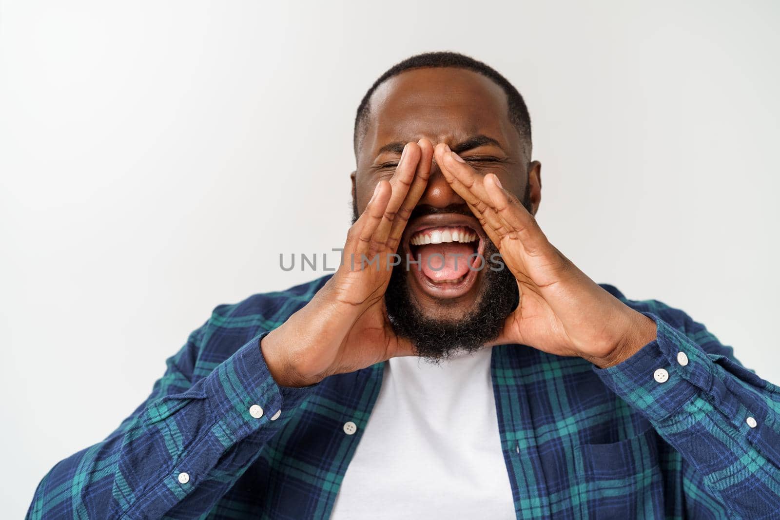 Young Afro-American man shouting. Shout. Emotional man screaming. Human emotions, facial expression concept. by Benzoix