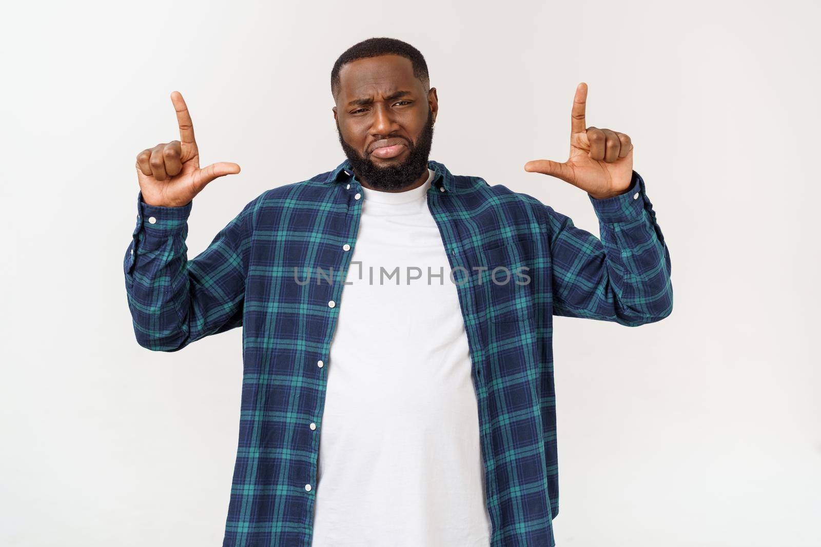 Young amazed African American pointing his finger at white background with copy space for your advertisement by Benzoix