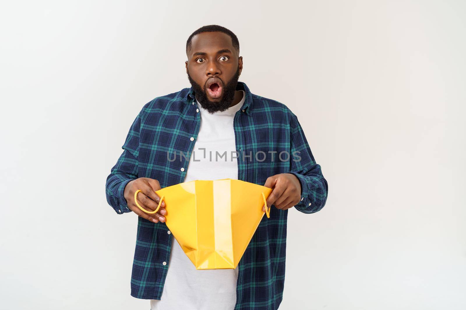 Happy african american man holding shopping bags on white background. Holidays concept.