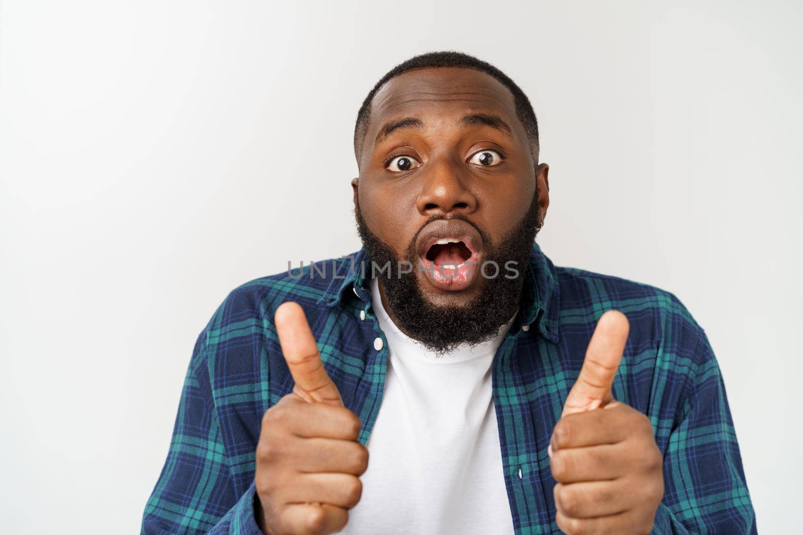 Portrait of happy afroamerican handsome bearded man laughing and showing thumb up gesture