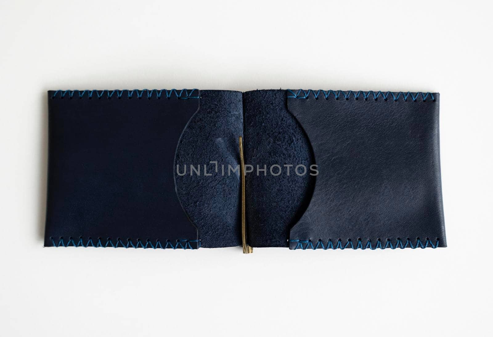 Open empty blue money clip handmade from genuine leather on white surface. by vovsht