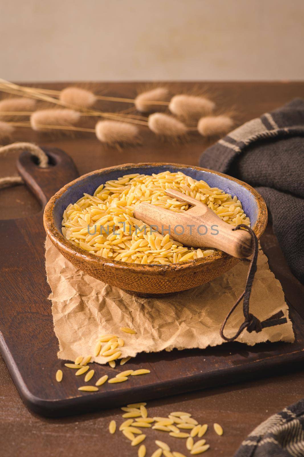 Dry risoni pasta in a ceramic bowl  by homydesign