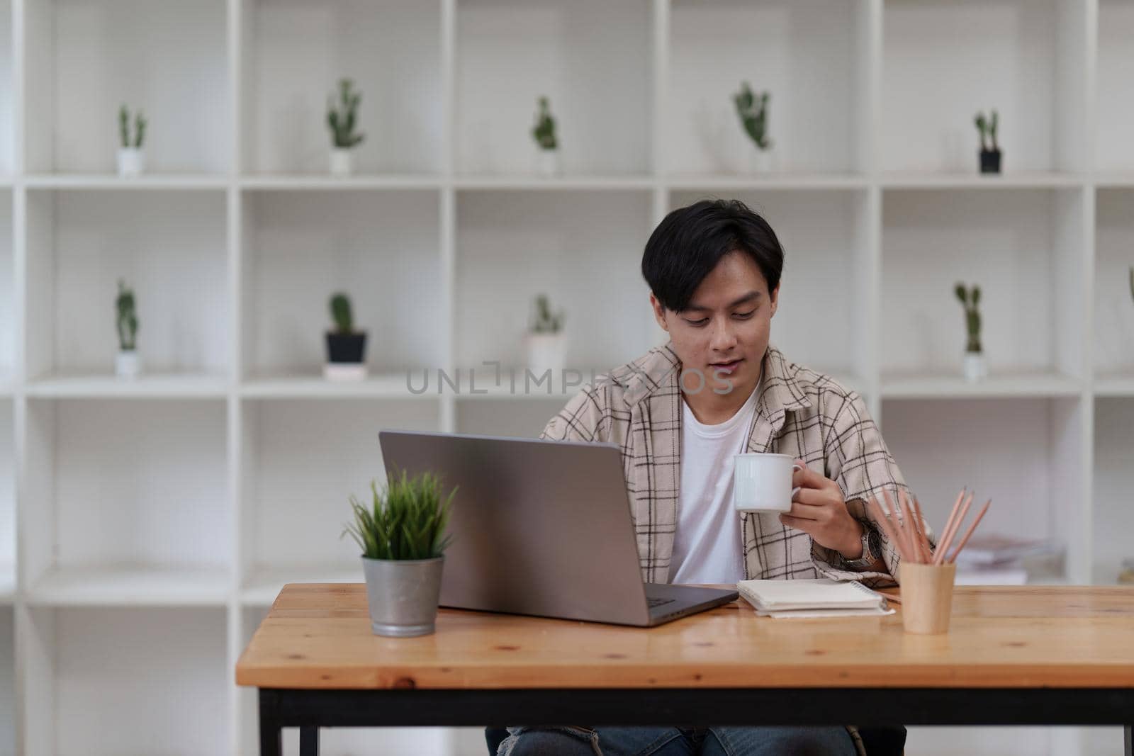 Asian man using laptop computer working at office. Creative and new idea concpet.