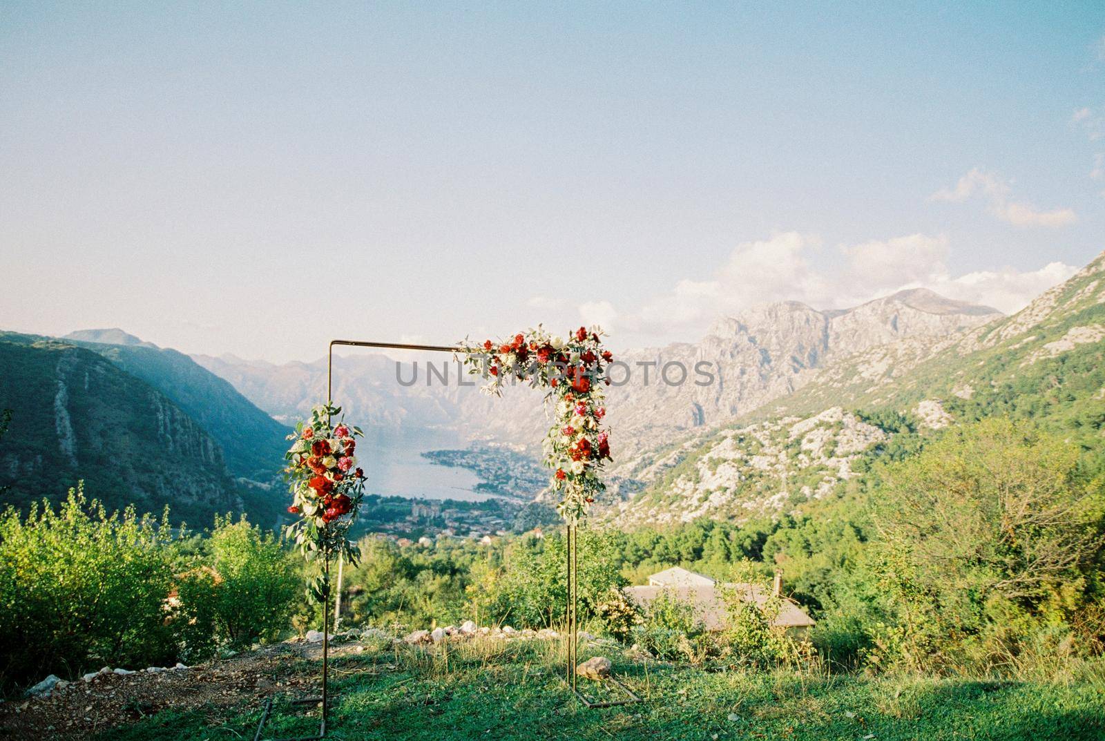 Rectangular metal wedding arch stands on a mountain overlooking the mountains and the bay. High quality photo