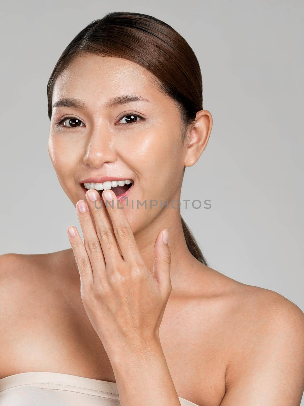 Closeup ardent young woman with healthy clear skin and soft makeup looking at camera and posing beauty gesture. Cosmetology skincare and beauty concept.