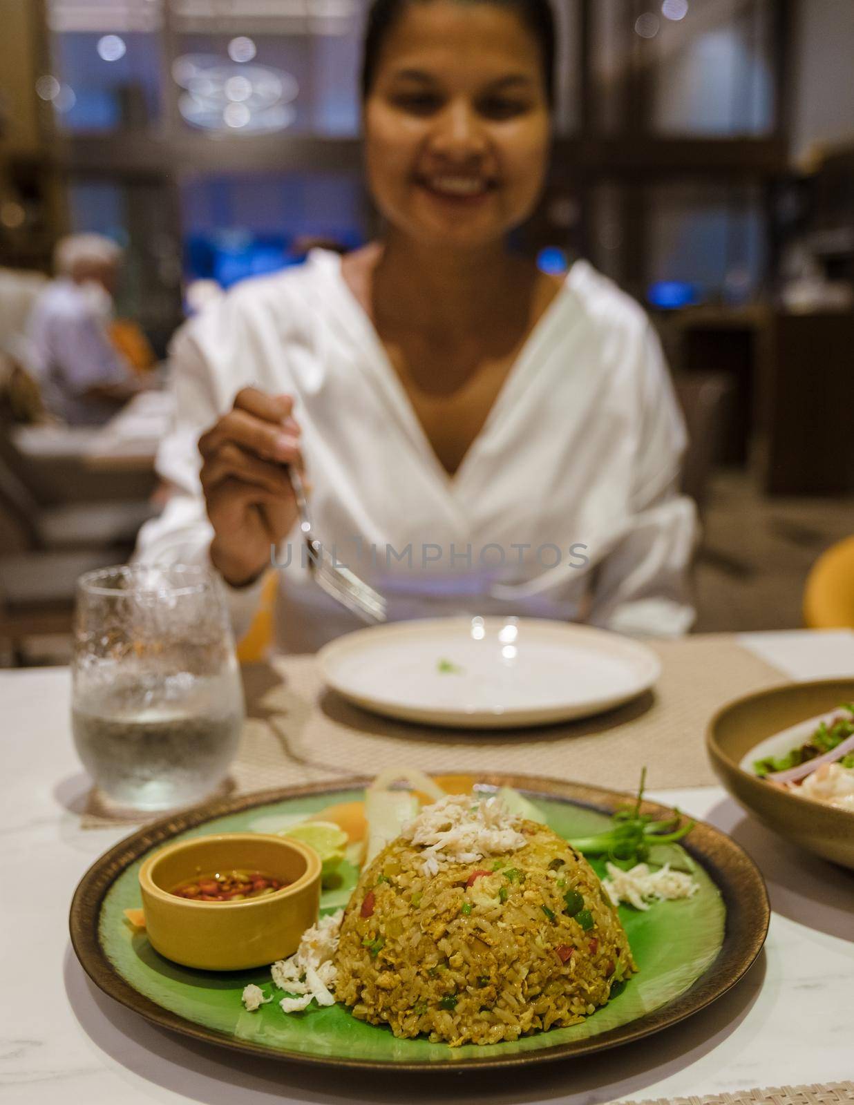 Fried rice mixed with yellow curry on a plate with hot chilli sauce by fokkebok