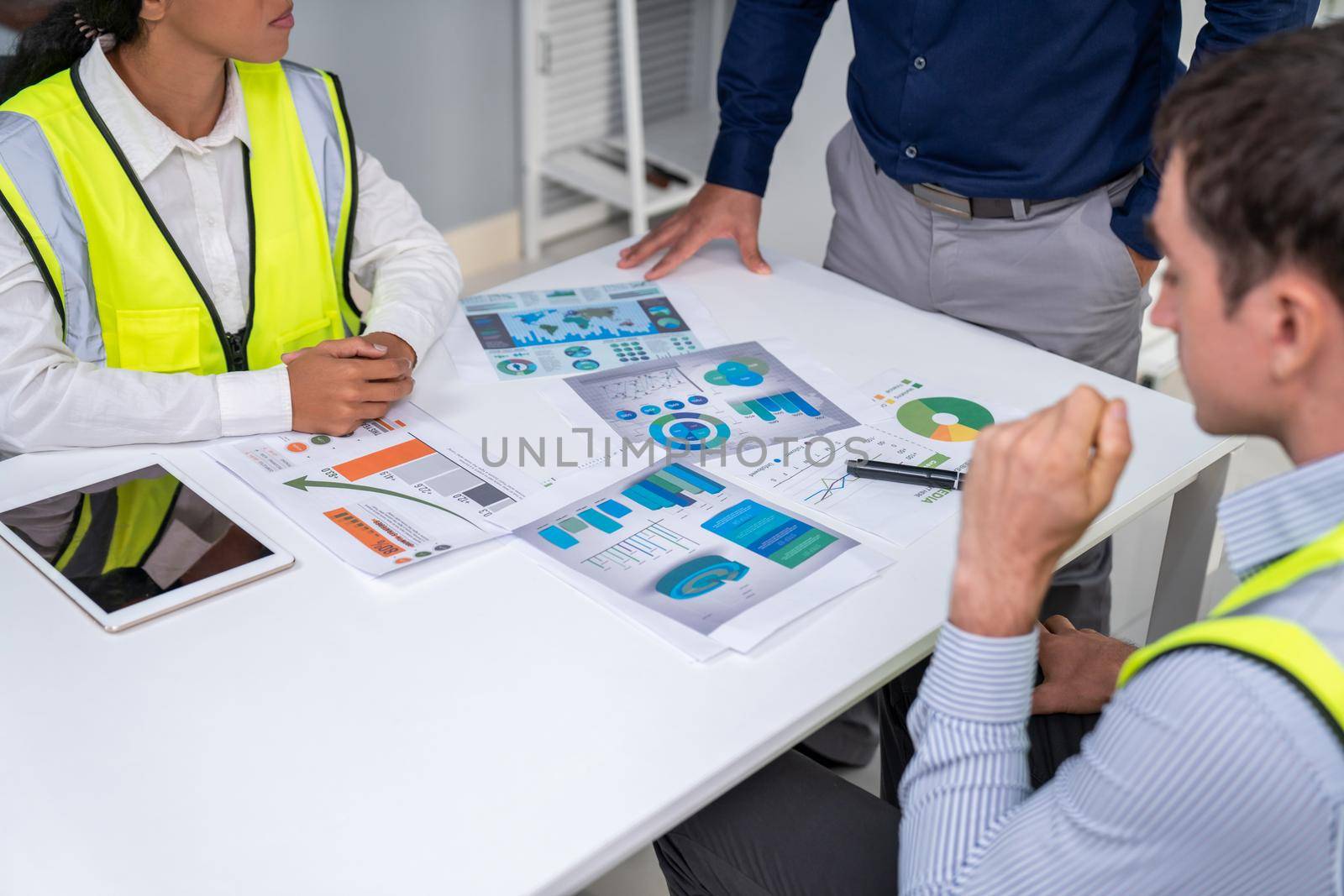 Engineers and competent employer discussing plans and blueprints together with tablet in the office. Concept of team contribution of ideas for engineering project.