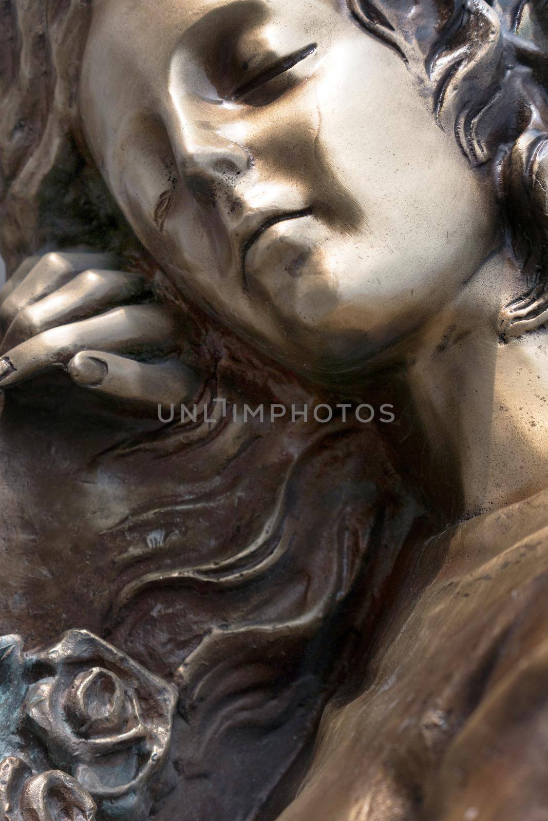 Vintage sculpture of sad woman in grief. Virgin Mary bronze statue. Religion, faith, suffering, death concept.