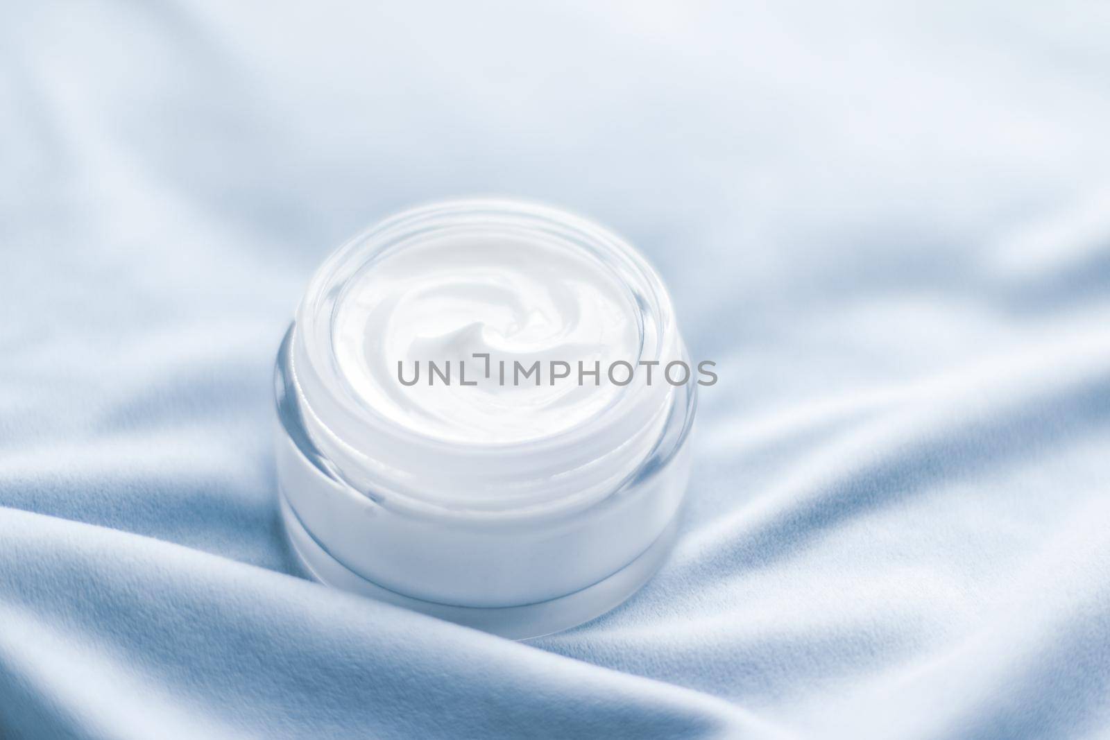 Beauty, anti-age cosmetics and skincare concept - Luxury face cream jar on blue silk