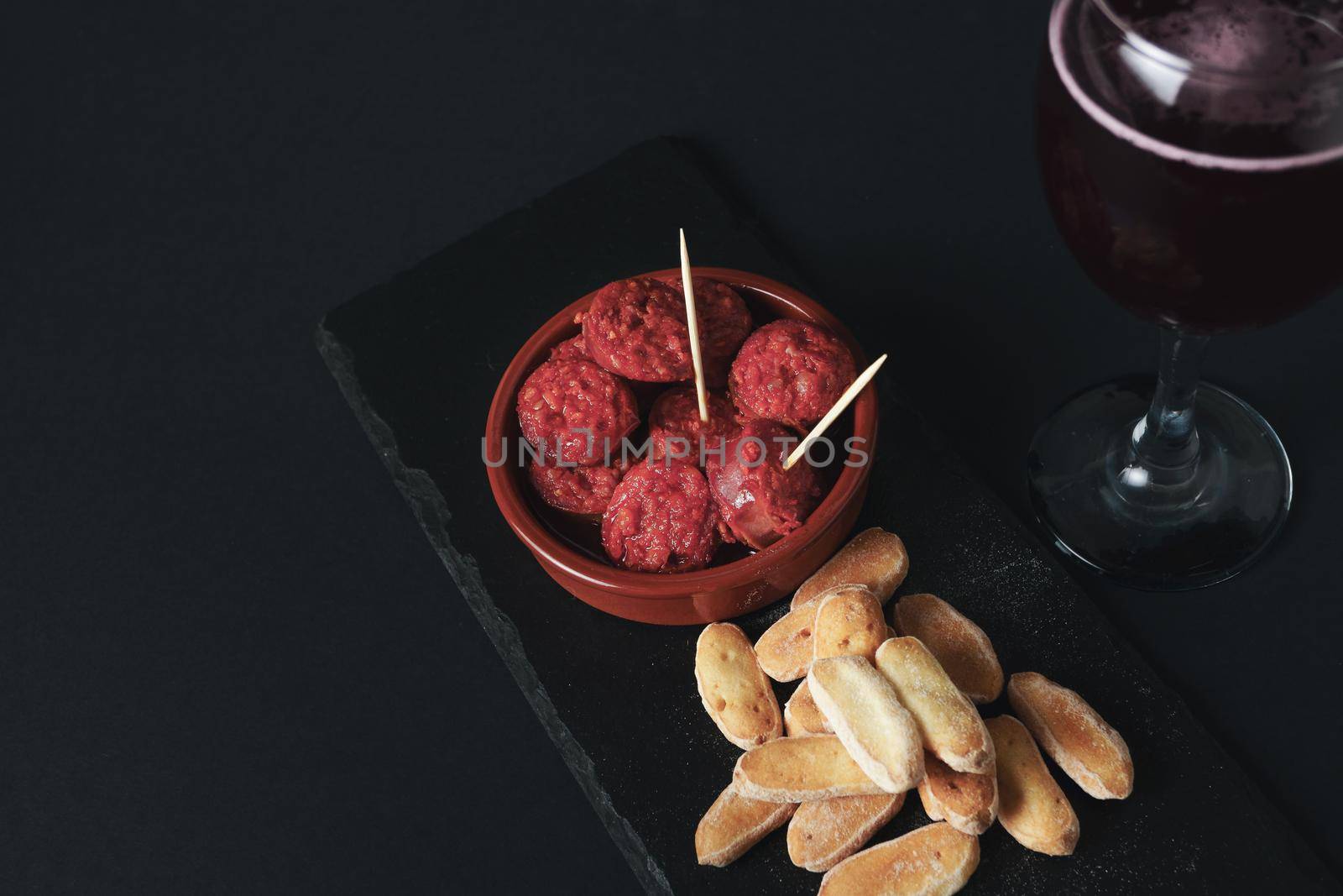 tapa of chorizo in typical spanish sauce with bread and summer red wine by joseantona