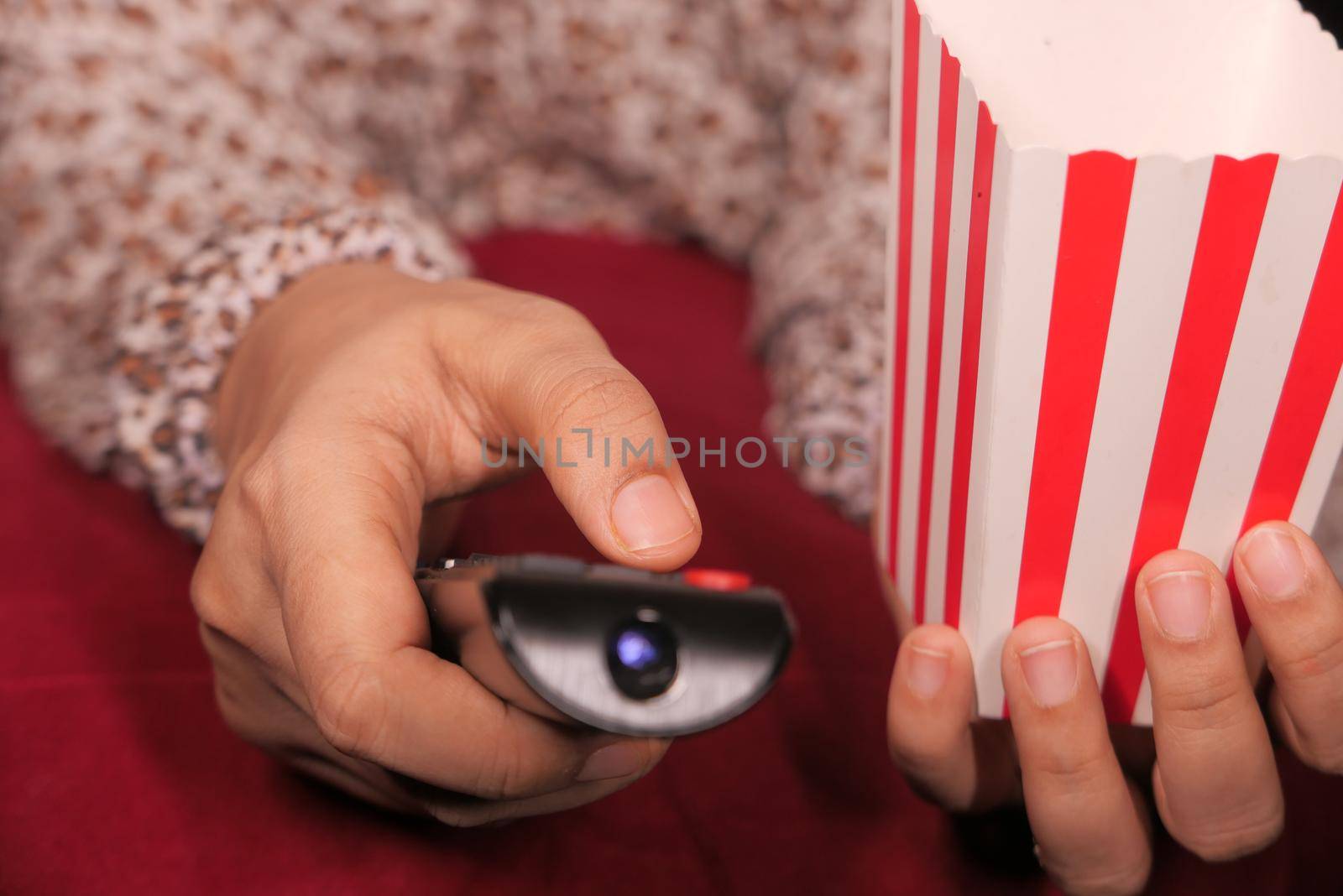 close up of women hand holding tv remote.