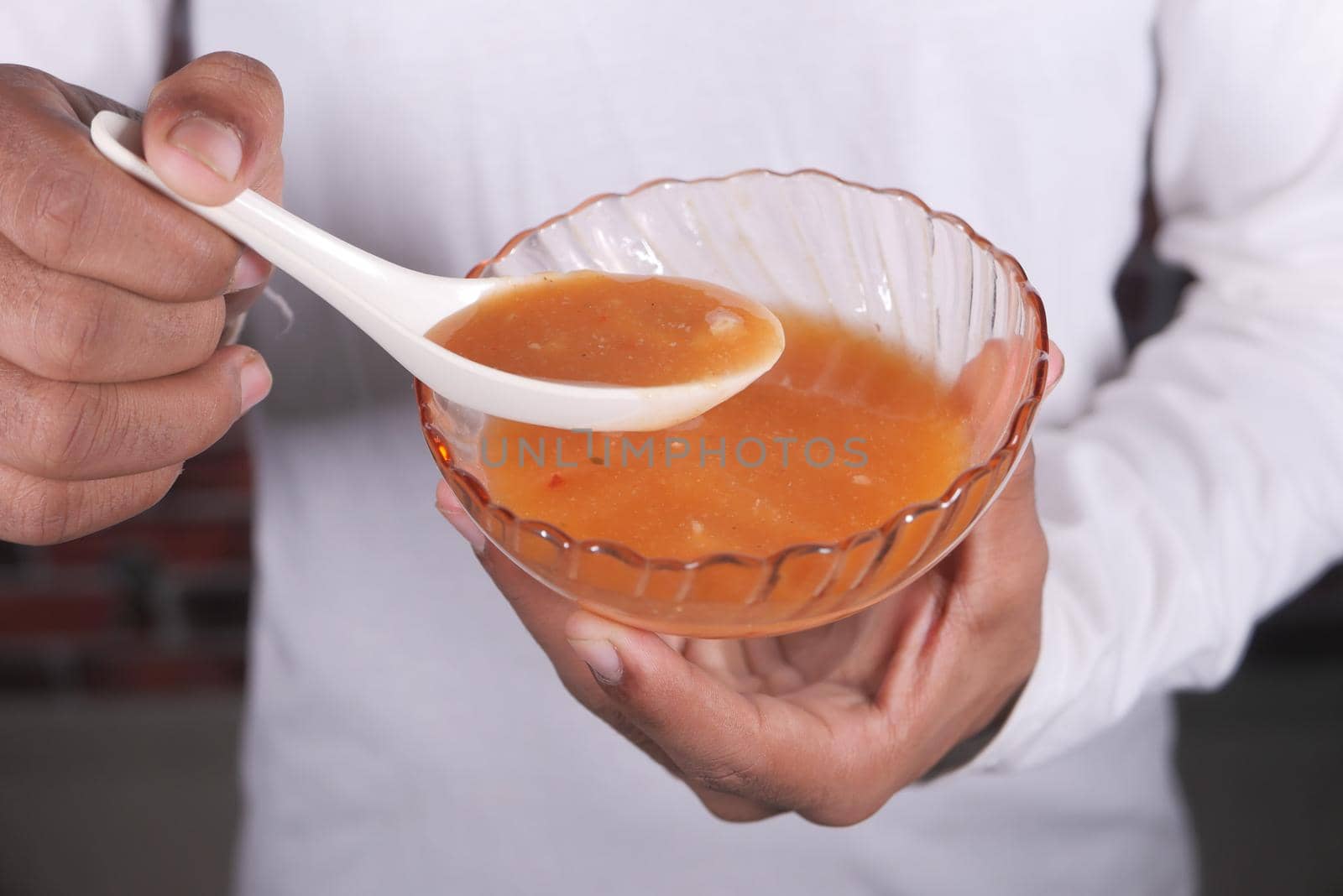 close up of man's hand eating thai hot spicy soup .