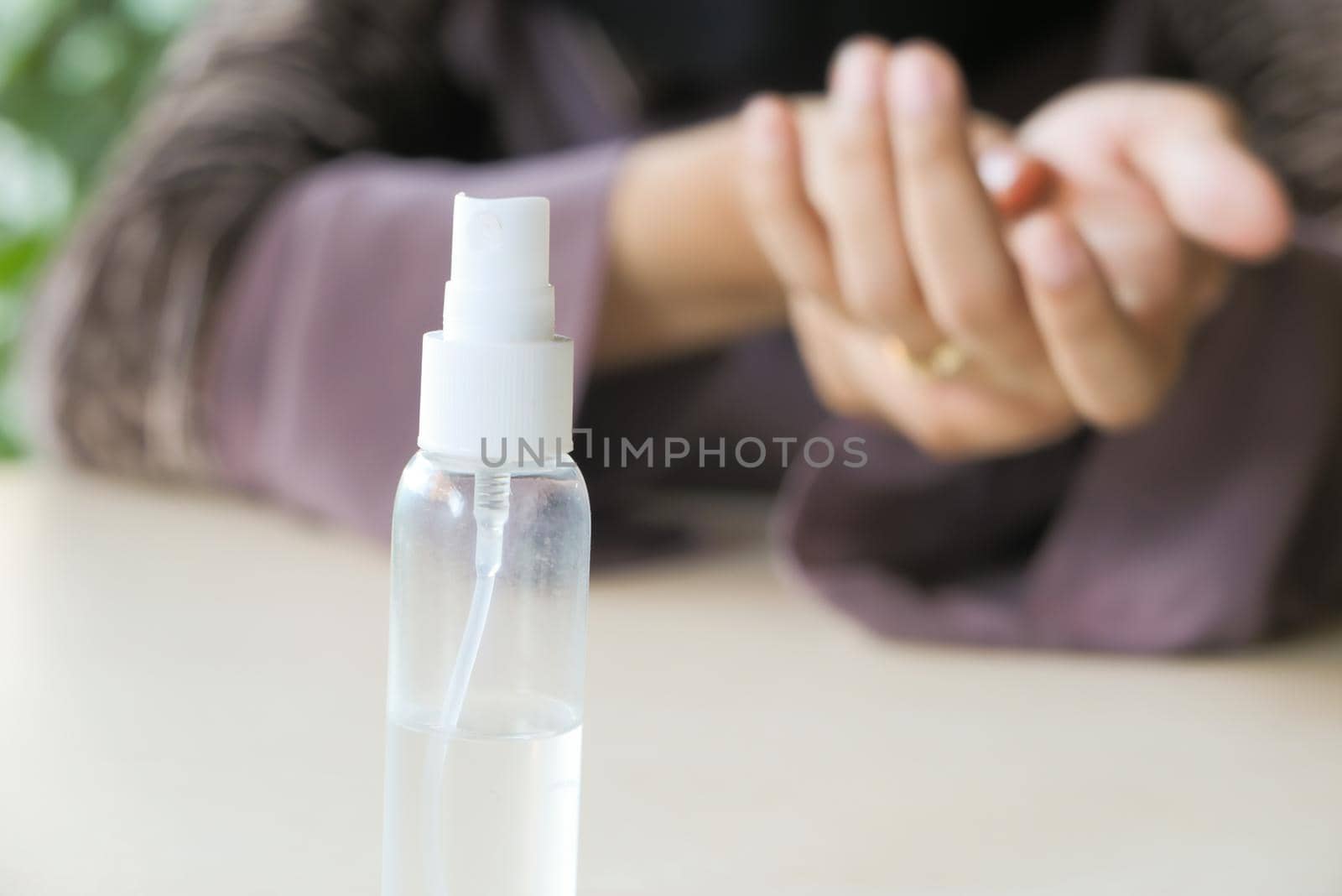 selective focus. sanitizer gel on table and women using sanitizer gel on background