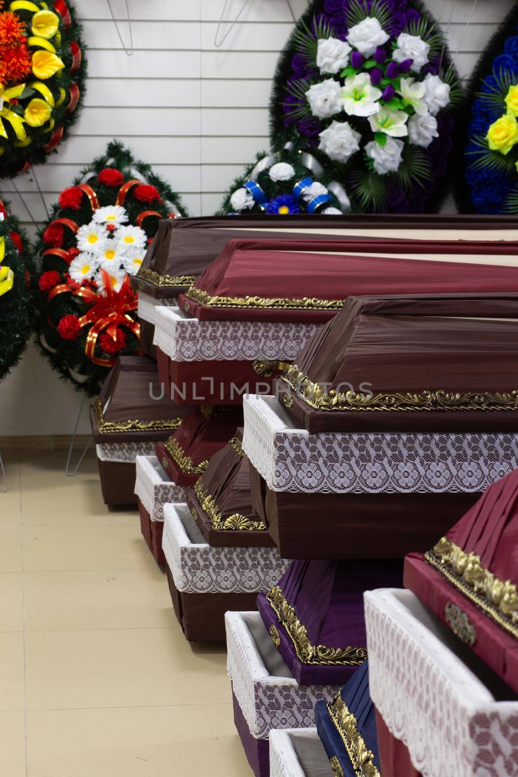 Interior of room with funeral accessories. Shop selling coffins, funeral wreaths and flowers.