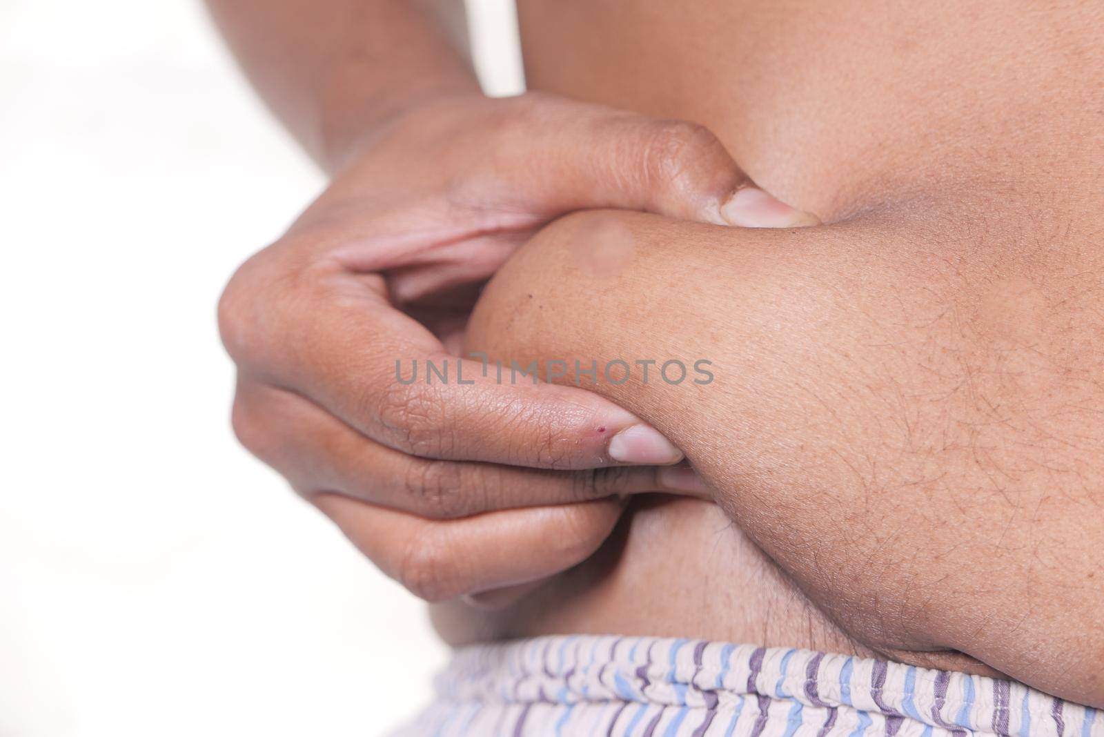 man's hand holding excessive belly fat, overweight concept.
