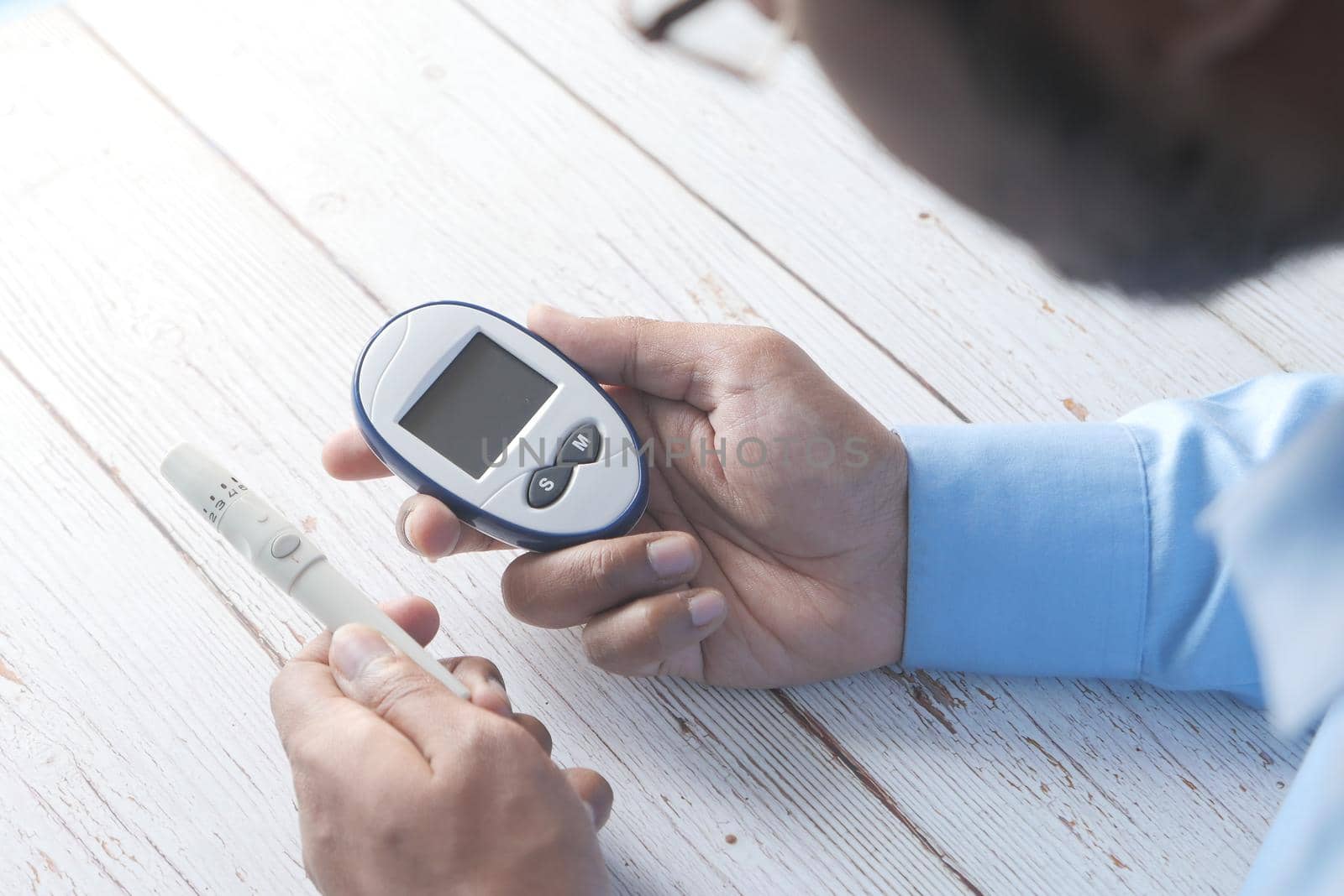 young man's hand measure glucose level at home.