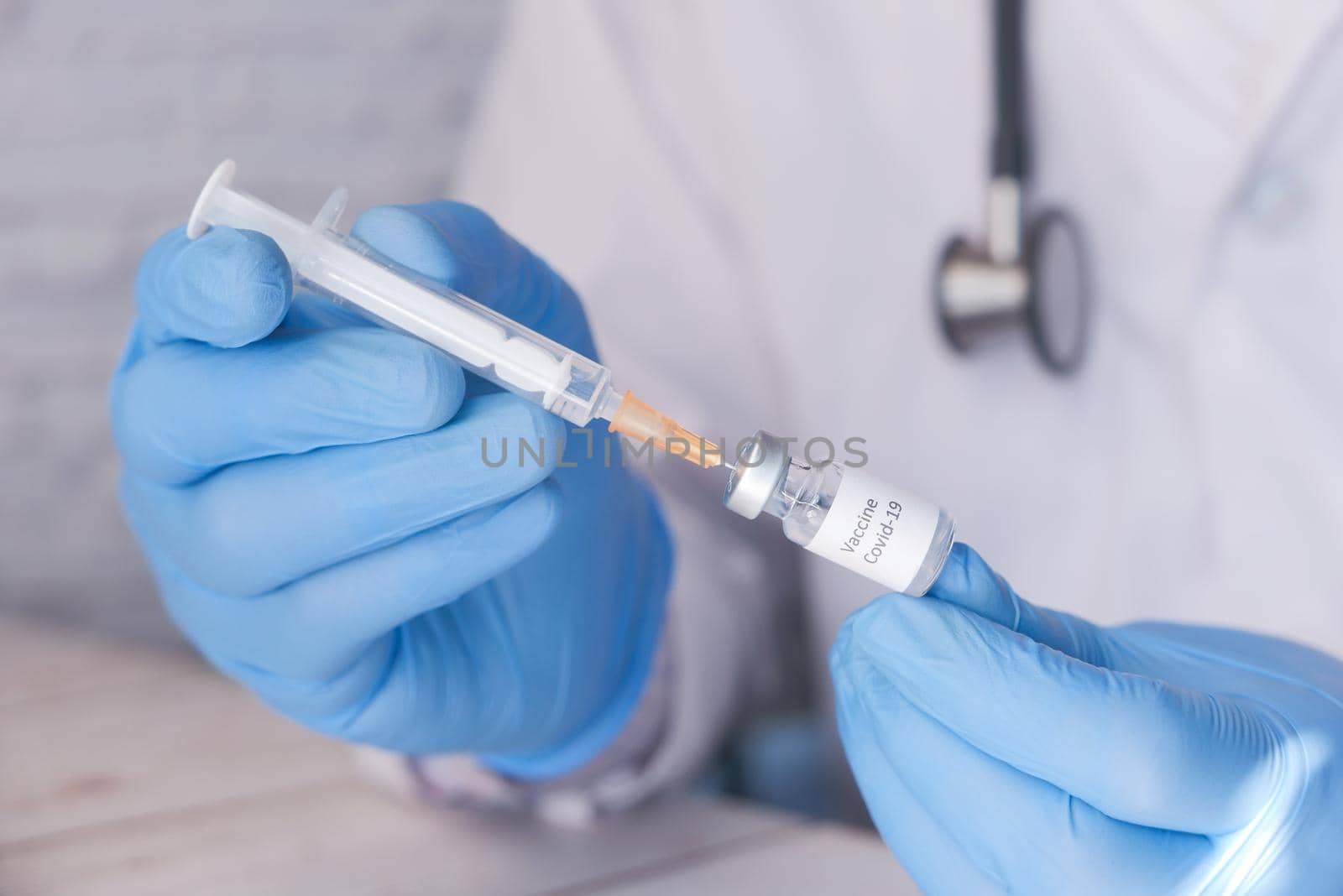Doctor hands in medical gloves holds syringe and vaccine