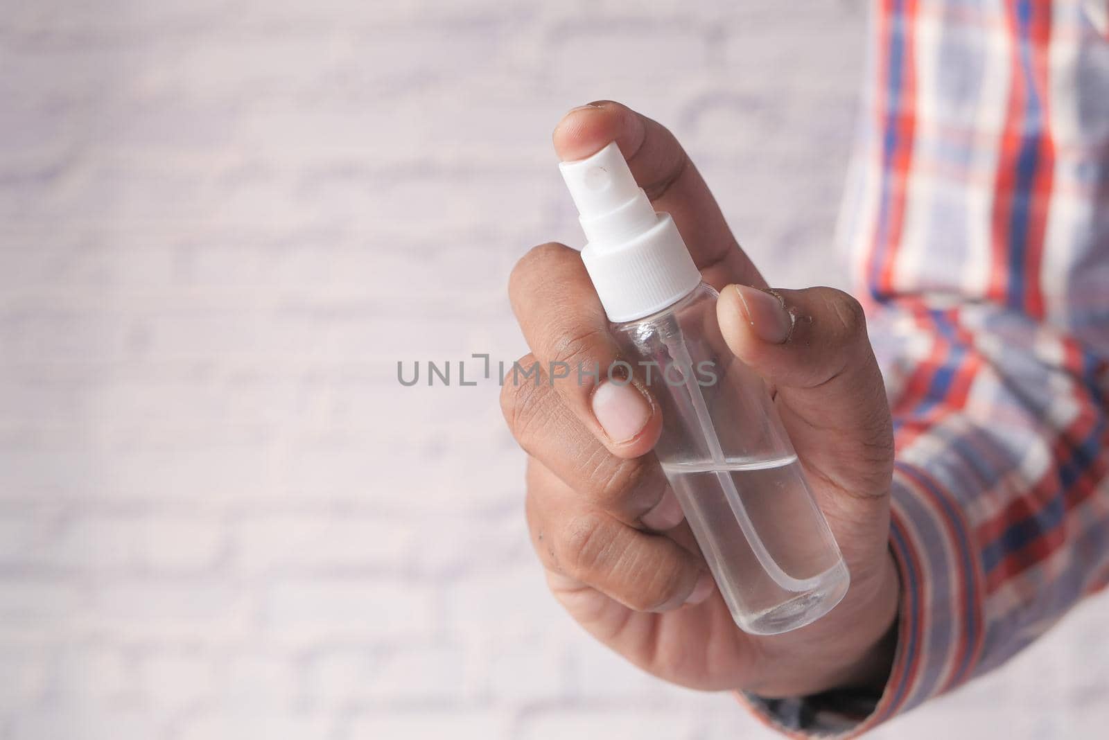 close up of young man hand using hand sanitizer spray