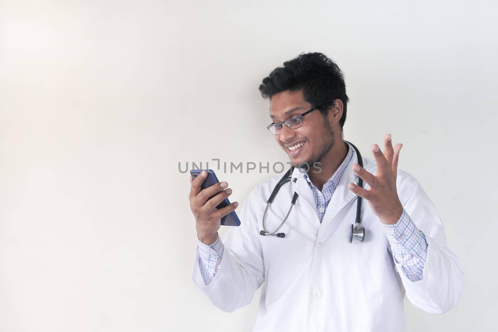 young asian doctor talking to smart shone camera in video chat