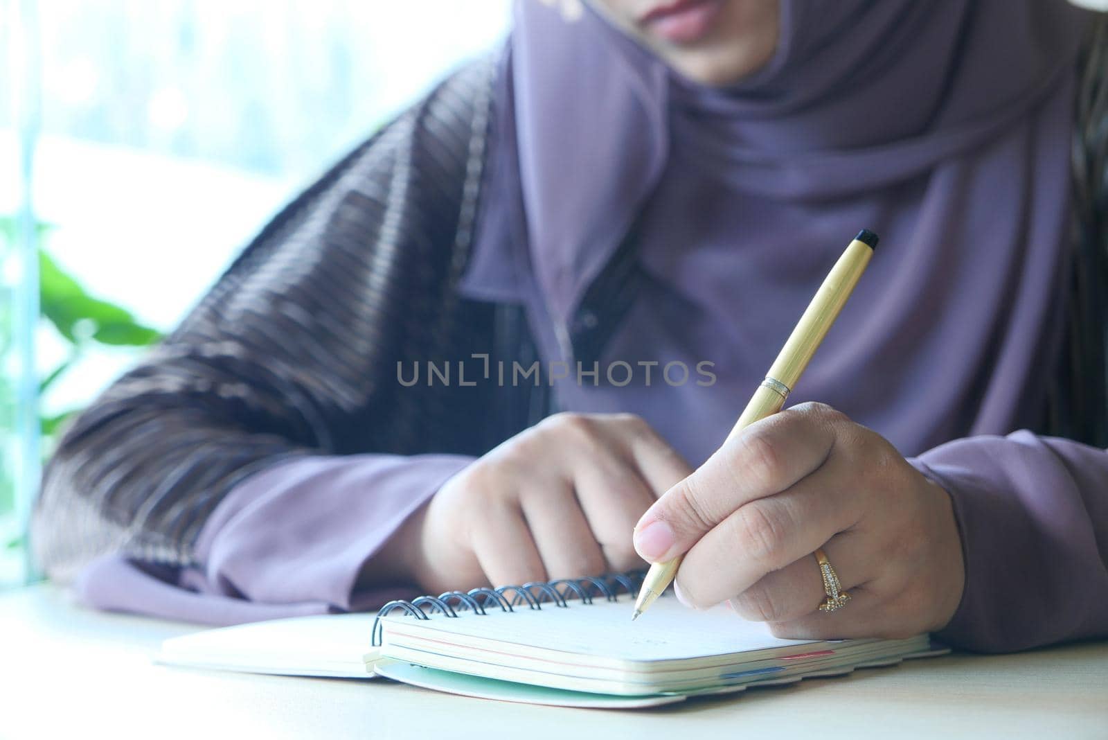 Close up of women hand writing on notepad