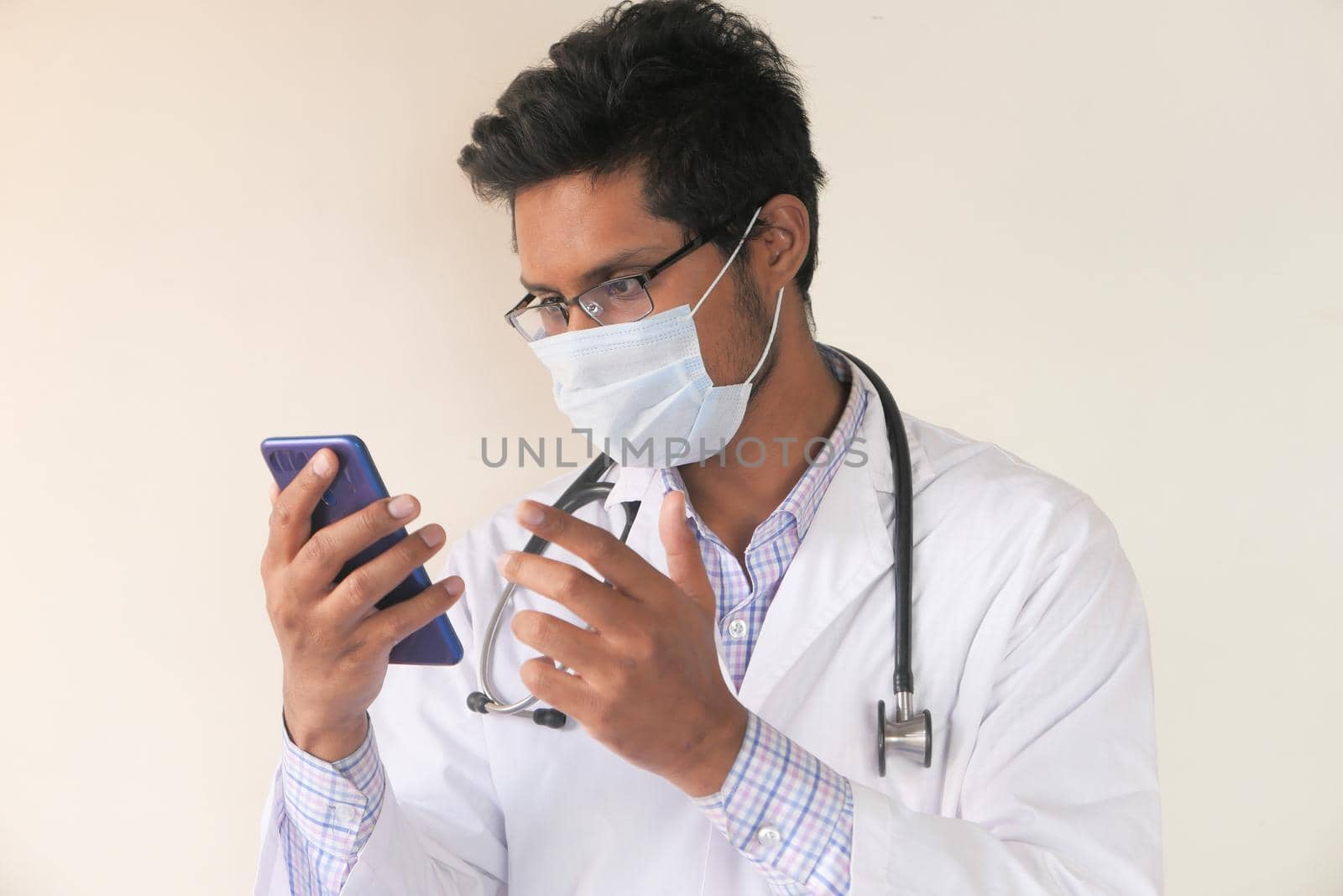 young asian doctor talking to smart shone camera in video chat