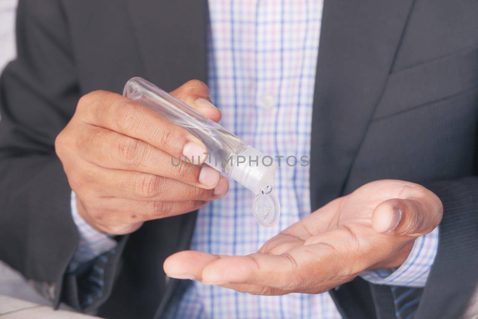 businessman using sanitizer gel on on office desk .