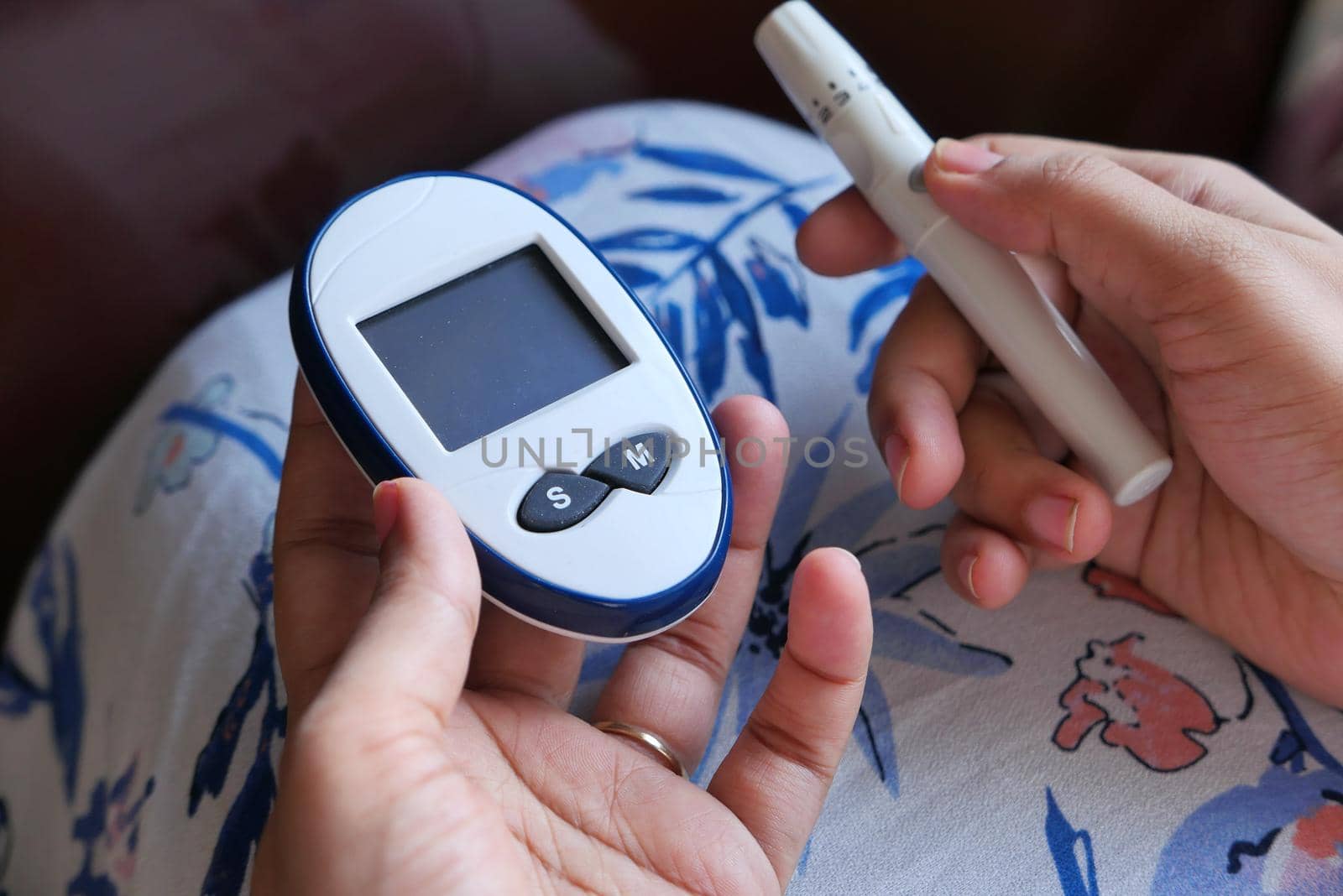 young women hand measure glucose level at home .