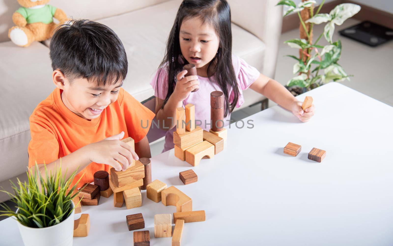 Children boy and girl playing with constructor wooden block building, Happy little kids play wood block stacking board game at home, activities learning creative, toys for preschool and kindergarten