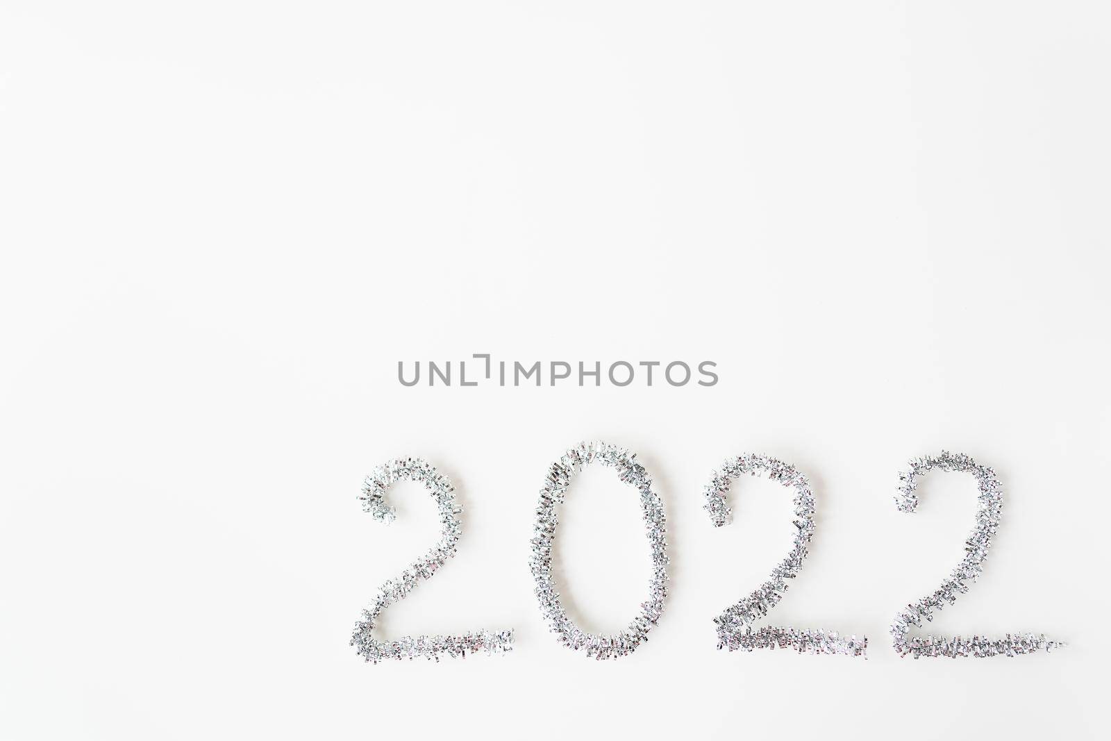 Happy new year 2022 written in foil and new year rain on an isolated white background. Happy new year greetings