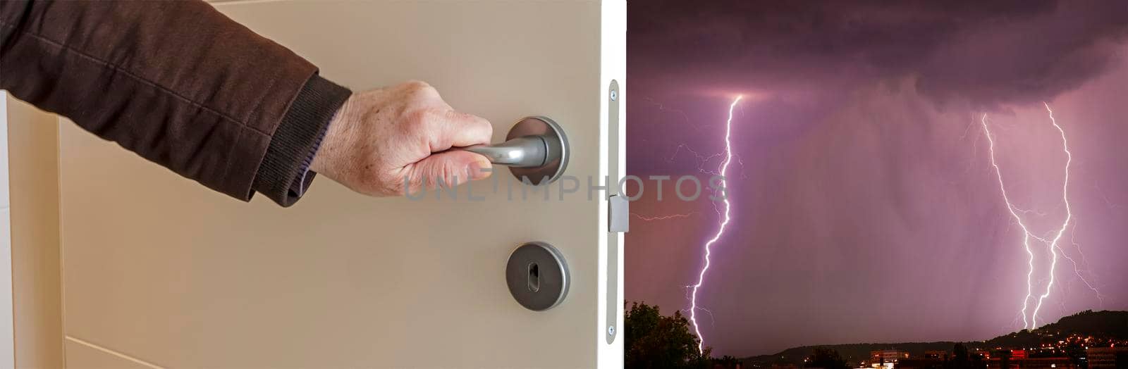 Close-up view of male hand opening door to thunderstorm with flash. Banner view by EdVal