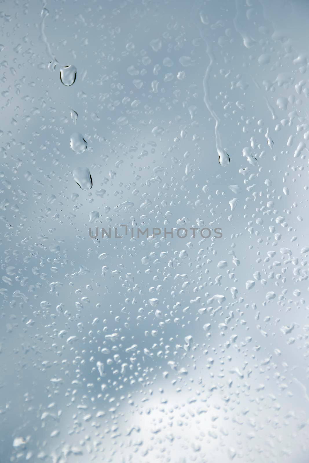 Close up of a window with raindrops. Vertical view