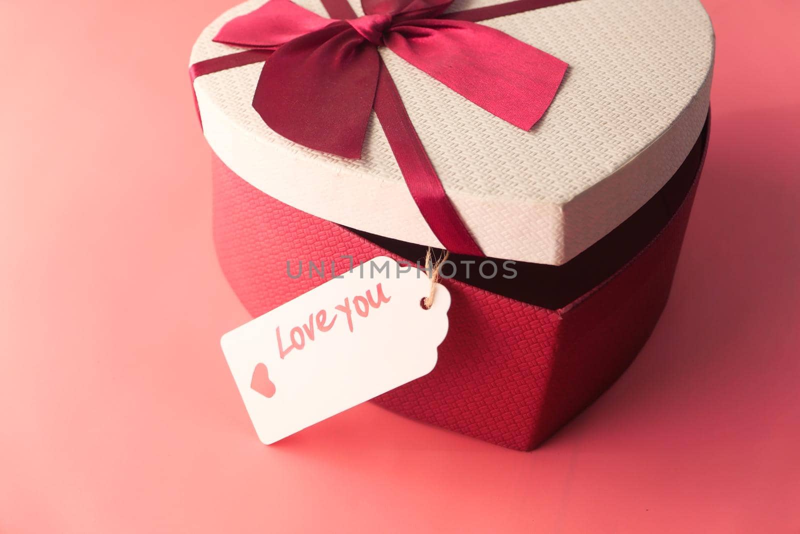 heart shape gift box on pink background .
