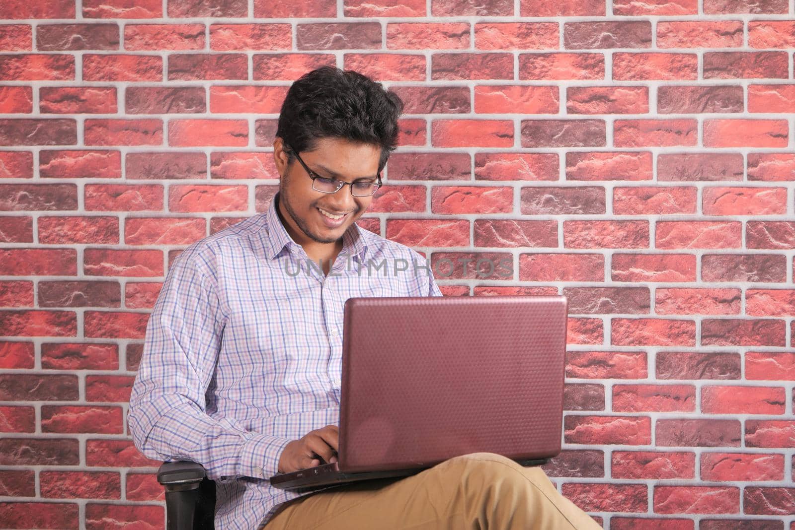 young man sitting on chair using laptop .