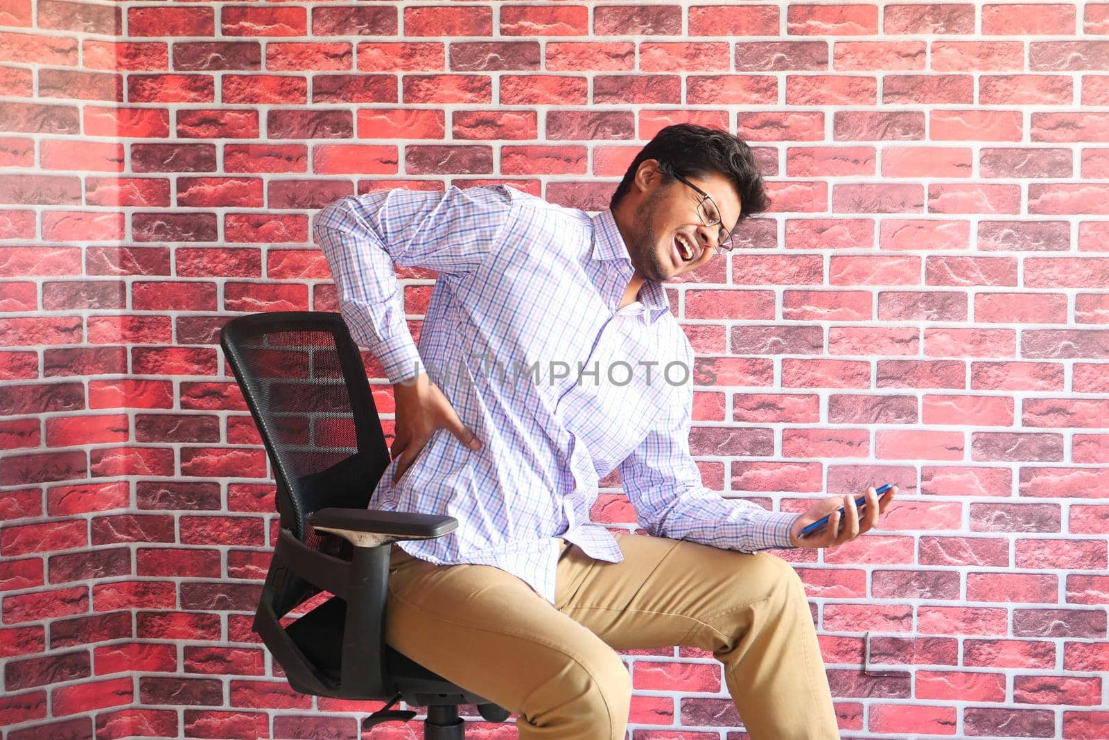 young man in blue shirt suffering back pain